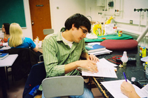 An AU Student works on a physics problem at a desk